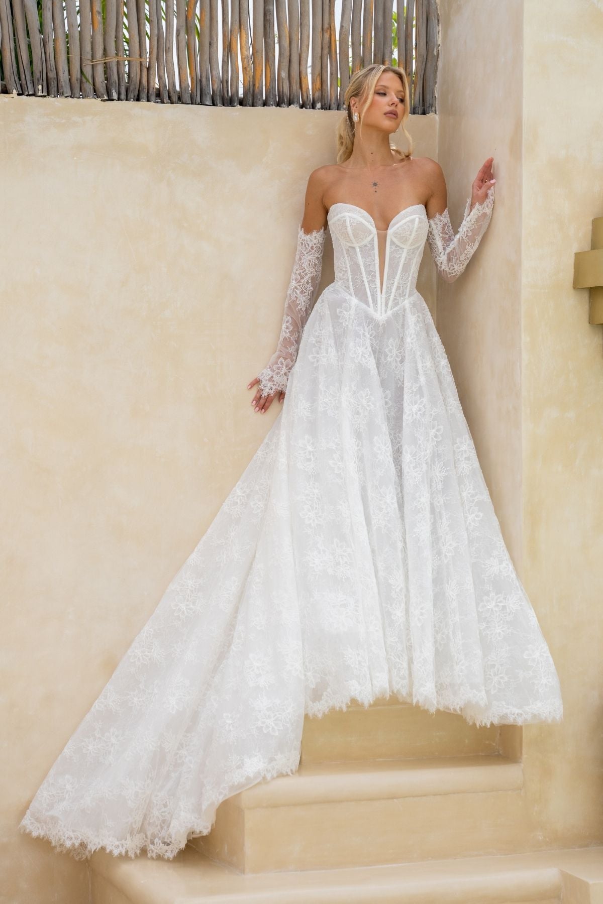 Lace A-line wedding gown with deep v plunge and sweetheart neckline, basque wasitline and fitted lace sleeves. 