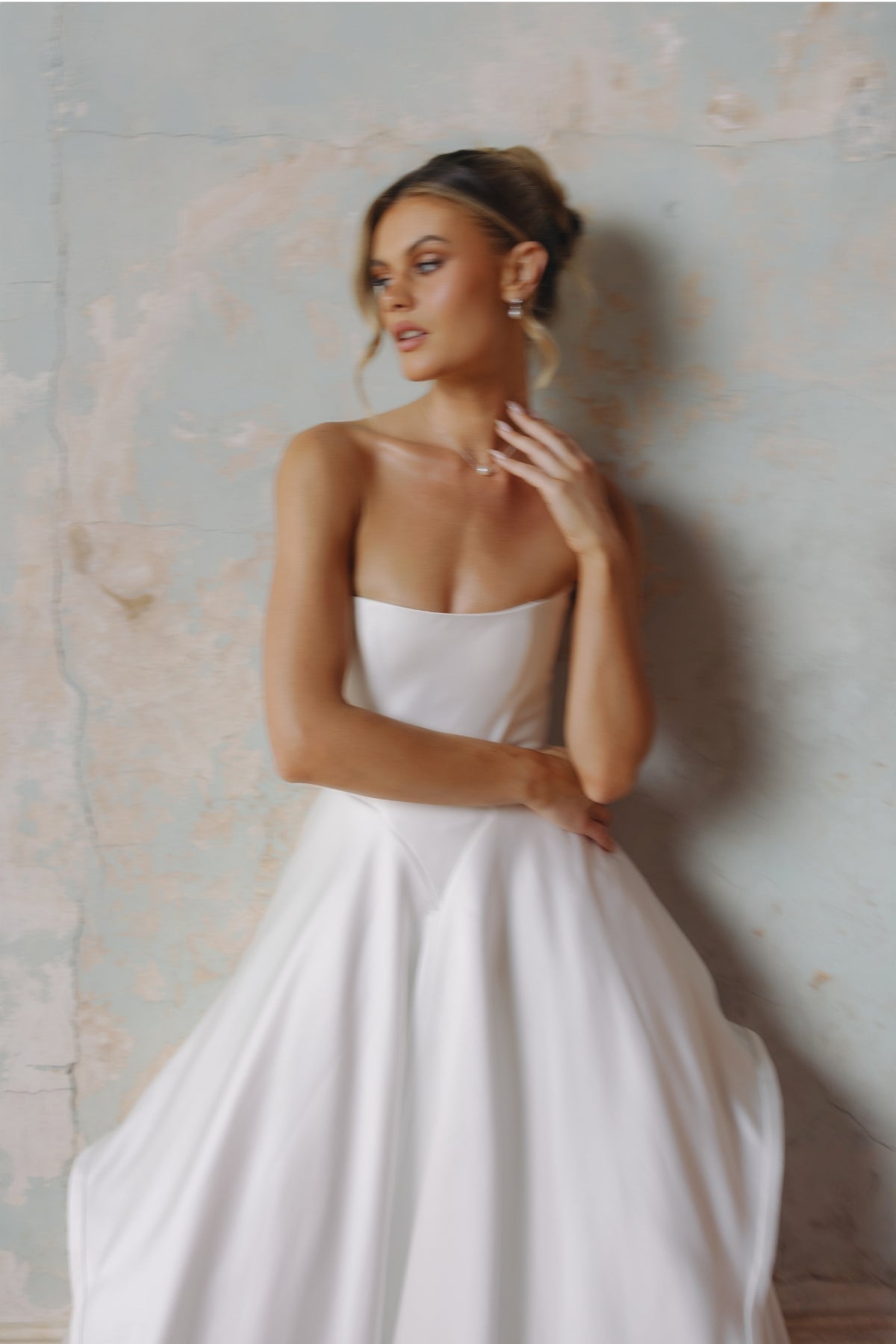 Strapless A-line satin wedding gown featuring cut drapes on the skirt 