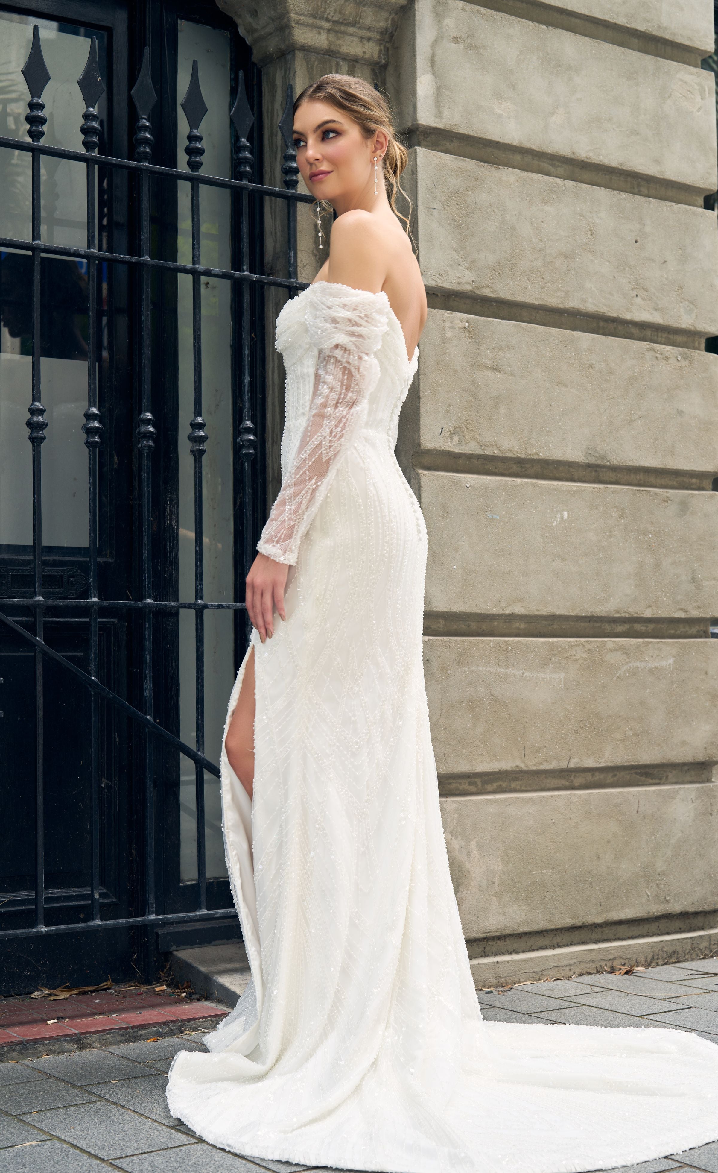 Fully beaded off the shoulder gown with sheer sleeves. Fit-n-flare silhouette, bust rouching and boned bodice.