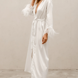 side view of full length satin look robe in ivory with feather cuffs