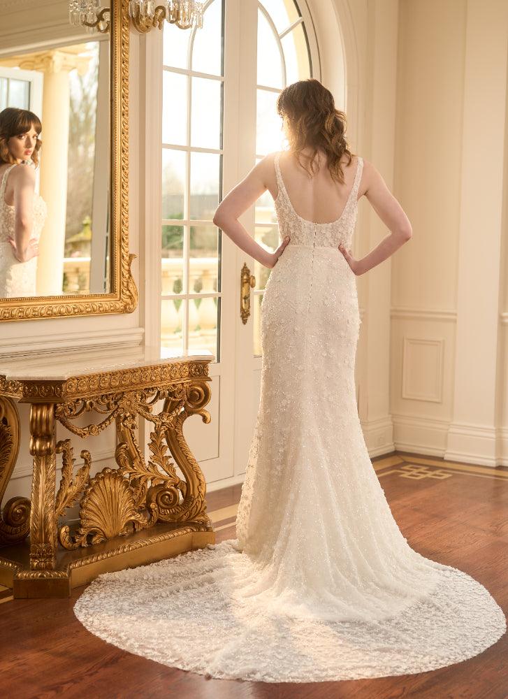Back view of Kristy. Ivory fit-n-flare wedding gown with delicate 3D florals and beads. Sheer boned corset with plunging backline imitating the square neckline. 