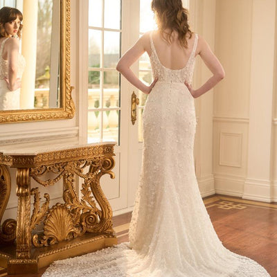 Back view of Kristy. Ivory fit-n-flare wedding gown with delicate 3D florals and beads. Sheer boned corset with plunging backline imitating the square neckline. 
