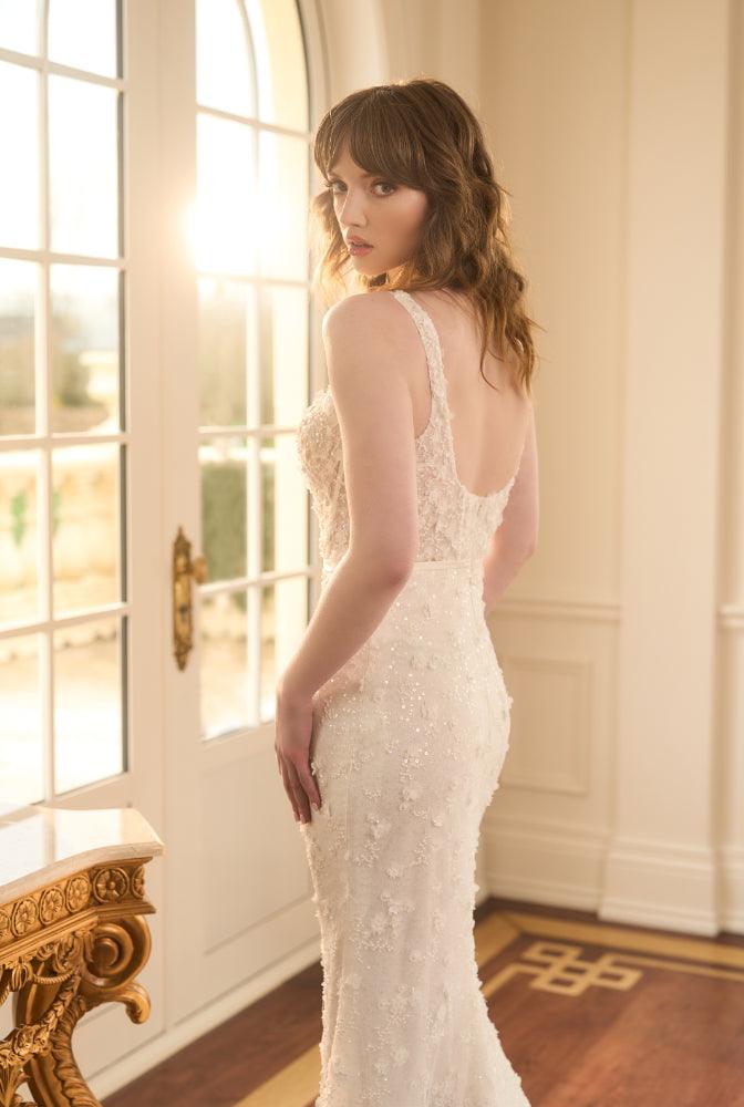 Side view of Kristy. Figure-hugging fit-n-flare style with 3D florals and beads. Plunging back that sits above waistline.