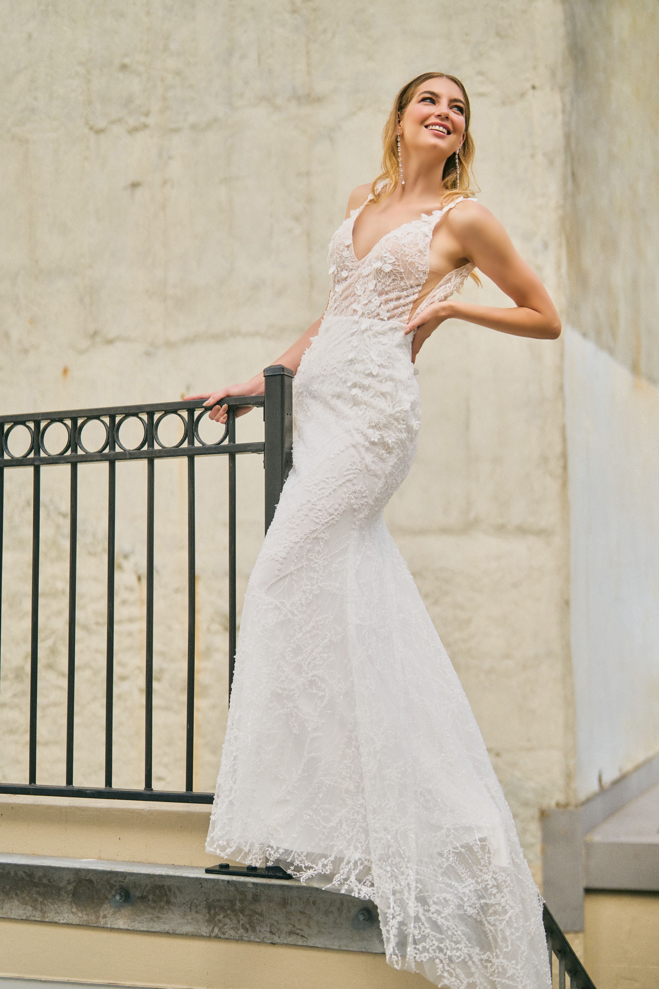 Rochelle wedding dress with mermaid silhouette, beaded and glittery fabric, plunging neckline, low-open back, and leaf detailing on the straps for a modern touch.