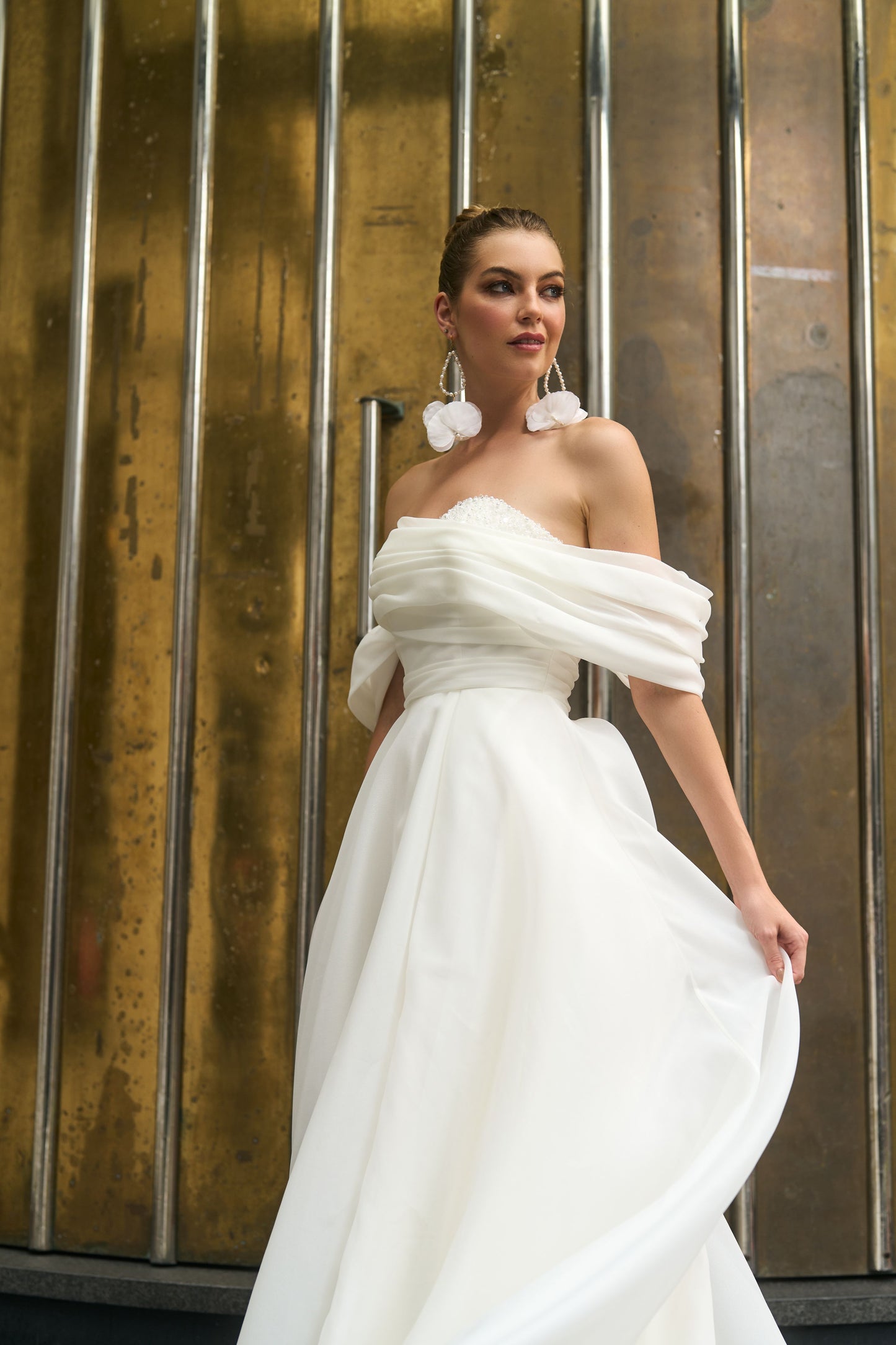 Rhianna wedding dress in sheer Organza fabric with off-the-shoulder pleated band and A-line silhouette. Wide waistband and light skirt with chapel train. High split adds a modern touch and ease of movement for walking and dancing all day.