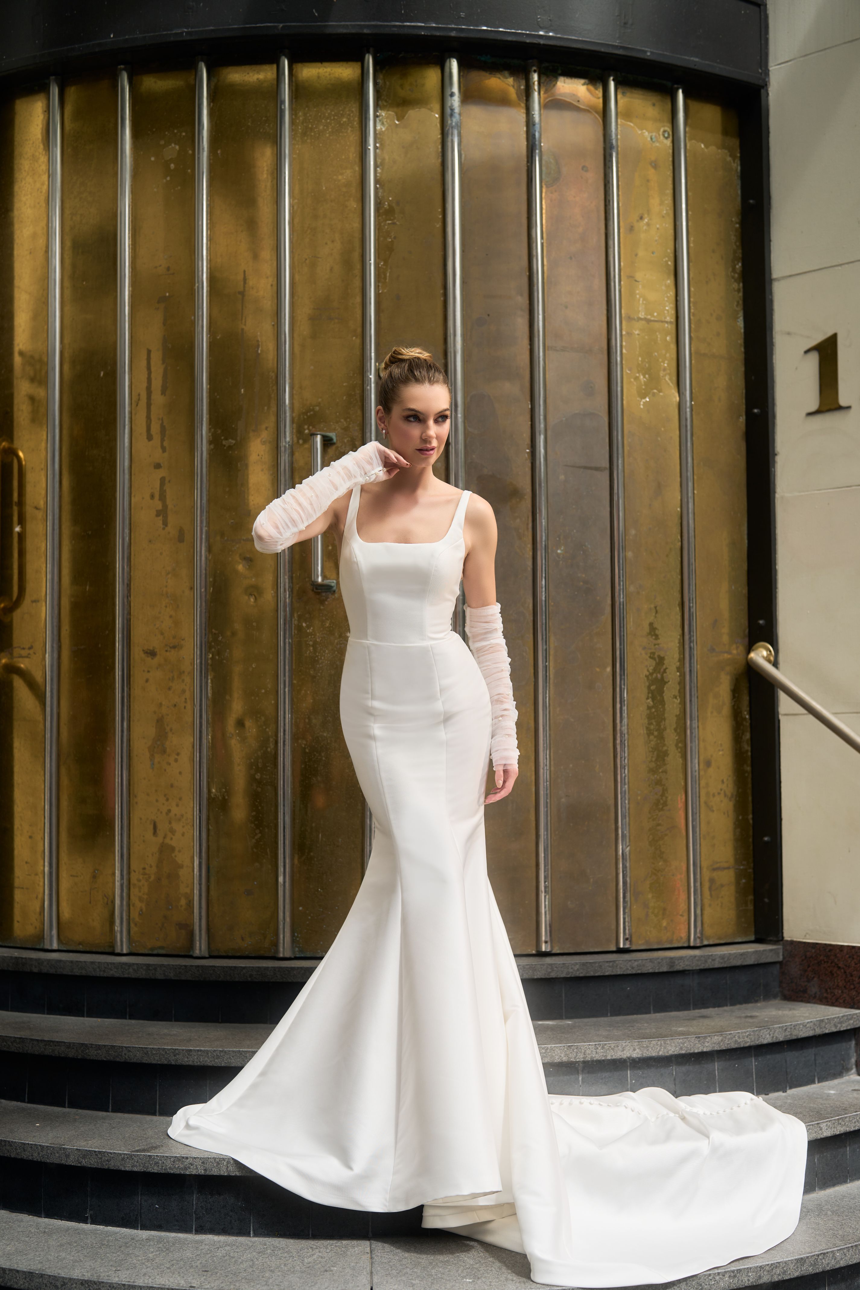 Ivory mikado minimalist gown with rouched tulle separate sleeves. Fit-n-flare shape with square neckline.