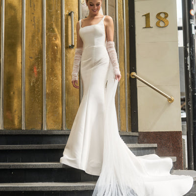 Ivory mikado minimalist gown with rouched tulle separate sleeves. Fit-n-flare shape with square neckline. Paired with 3-metre tulle veil with pearl embellishments.