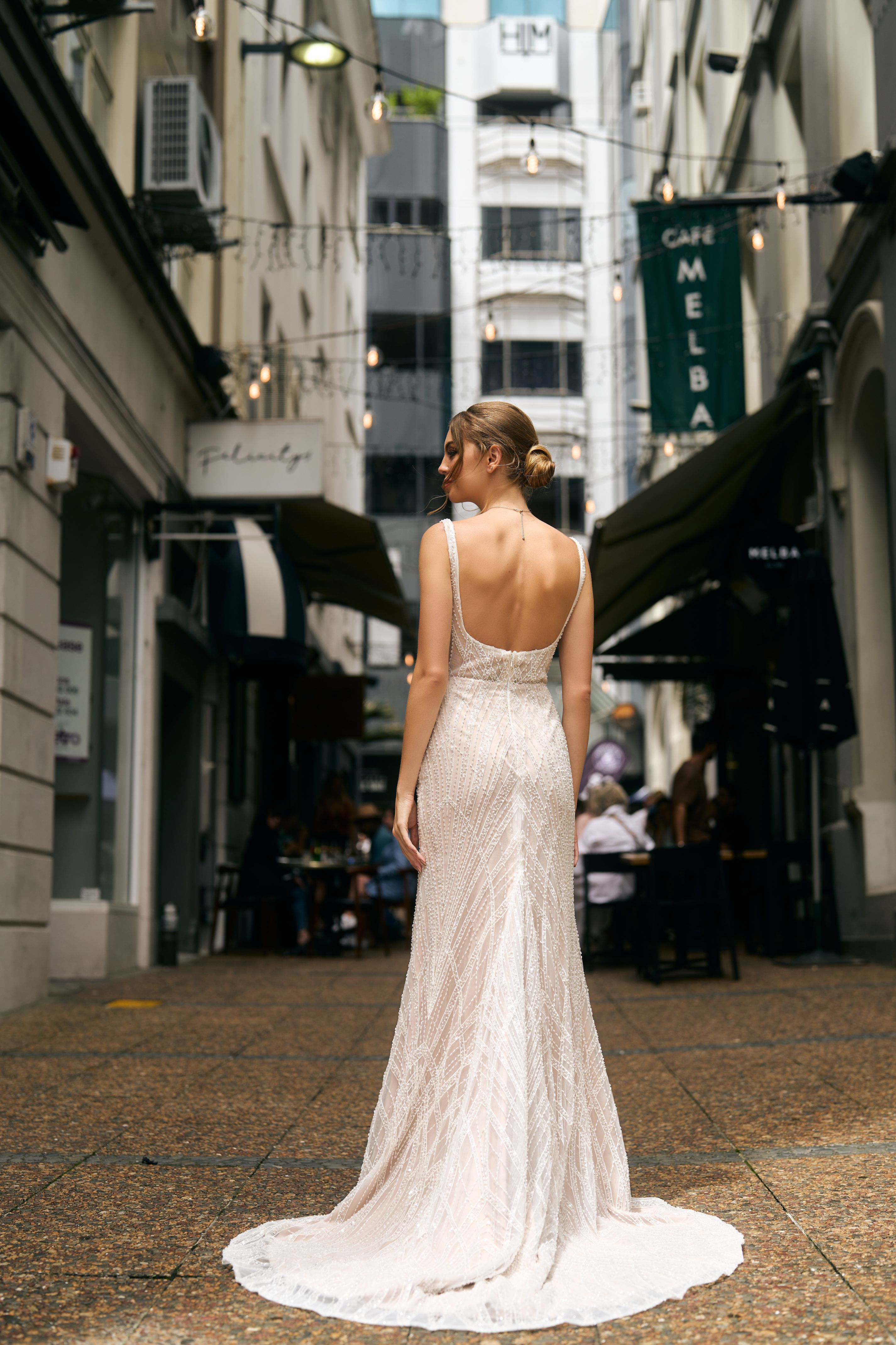 Fashioned with beaded lace, this fit-n-flare gown features a square neckline and fully boned bodice and beaded straps. Back view, low back with beaded train.