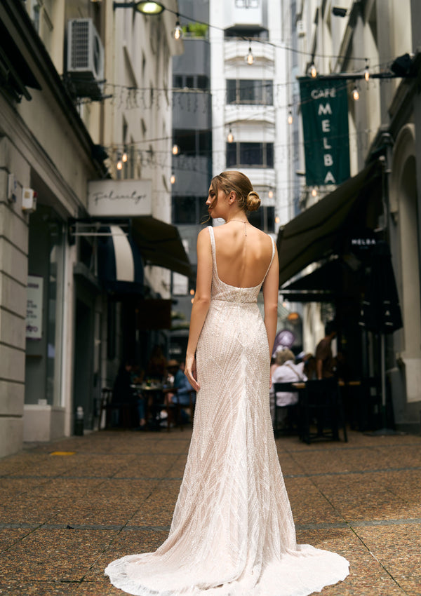 Fashioned with beaded lace, this fit-n-flare gown features a square neckline and fully boned bodice and beaded straps. Back view, low back with beaded train.