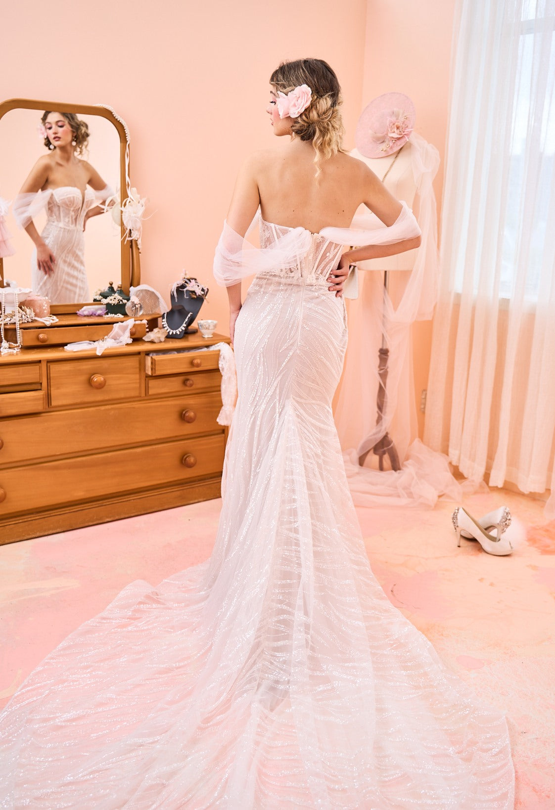 Model wearing fit-n-flare Sierra wedding dress with tulle off-shoulder sleeves from the Mademoiselle collection