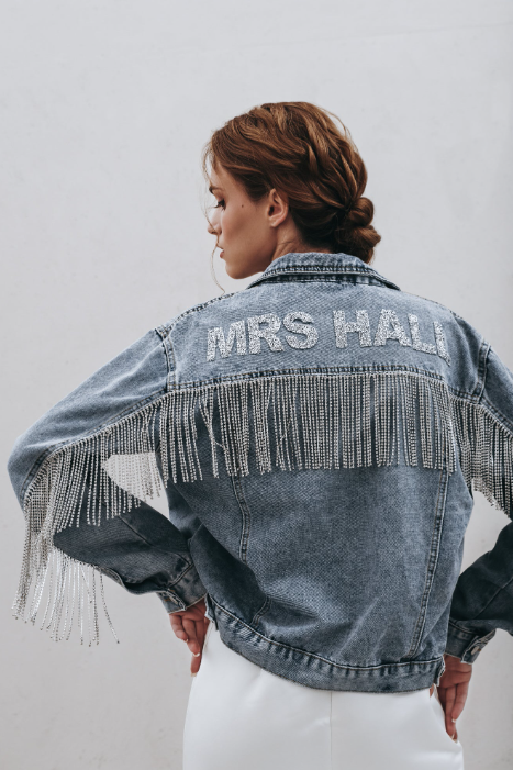 Back view of blue denim jacket with diamante fringe and lettering reading 'MRS HALL'