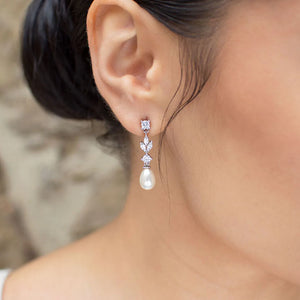 Cubic zirconia dangly earrings with oval shaped pearl at bottom.