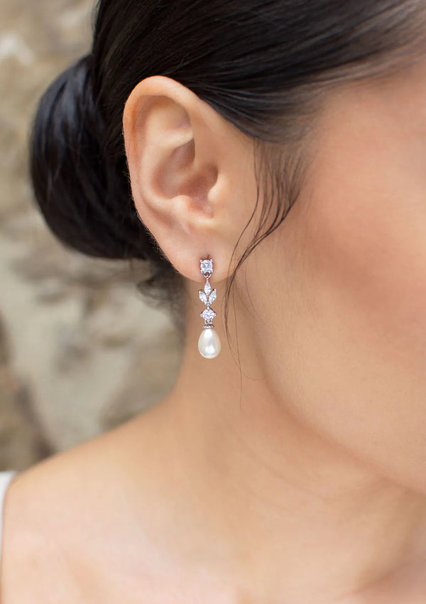 Cubic zirconia dangly earrings with oval shaped pearl at bottom.