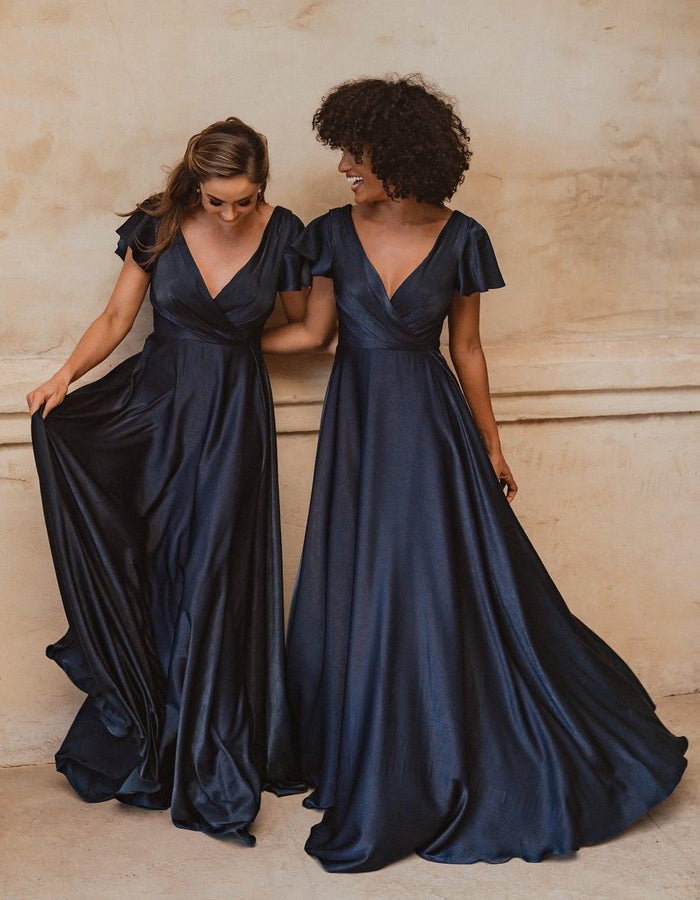 Auckland bridesmaid dress in midnight blue satin. Cross over neckline to waist with flared short sleeves and full length skirt