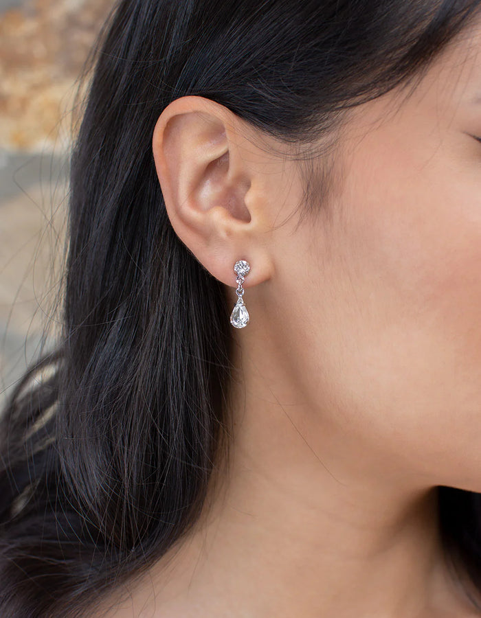 Narrow dangly earring of round and teardrop cubic zirconia.